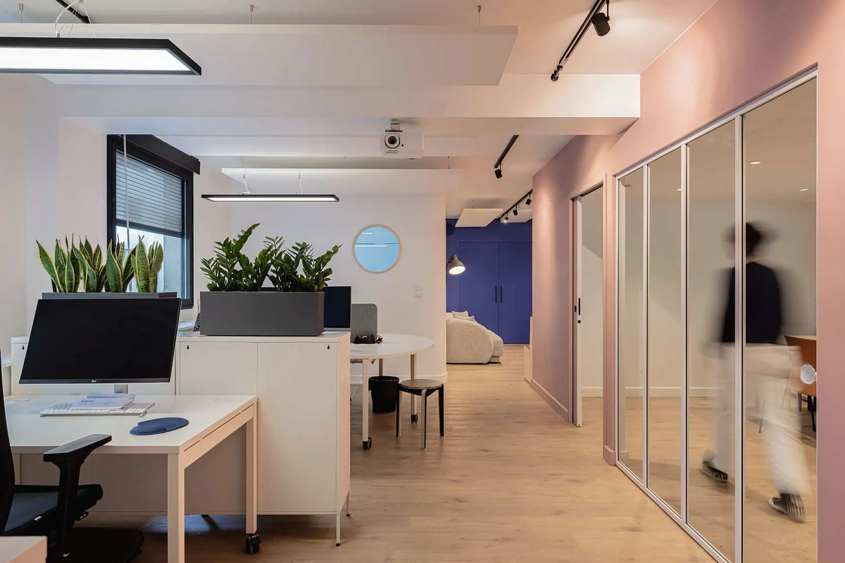 Aménagement de bureaux en open space avec cloisons vitrées, murs roses et bleu nuit, réalisé par Picture Design à Lyon