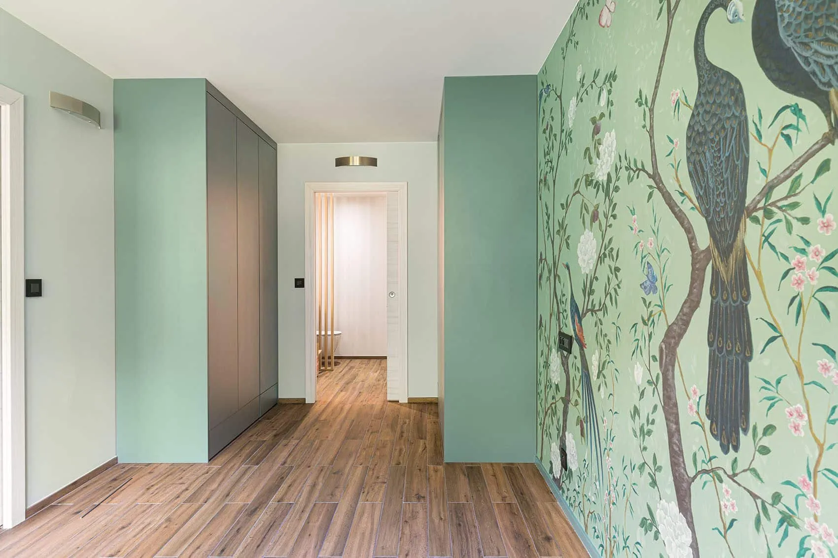 Couloir de l’appartement Gillet sur les quais de Saône à Lyon : placards vert d’eau et papier peint à motif d’oiseau
