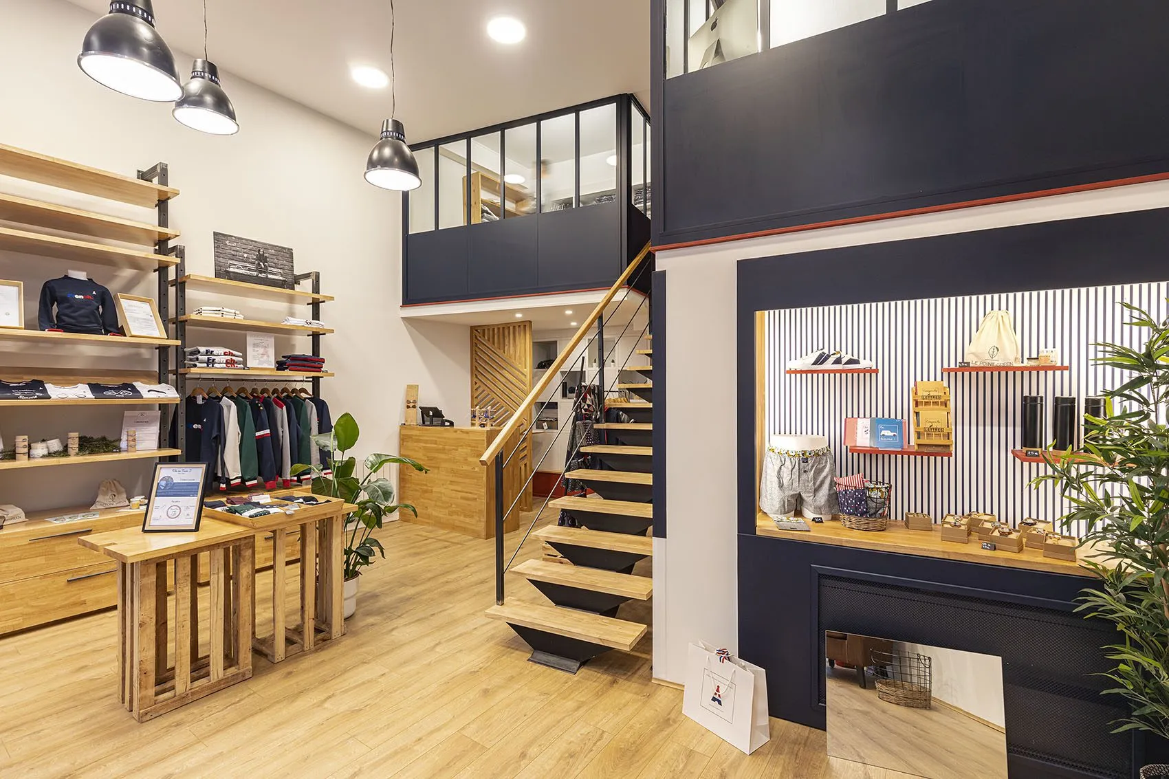 Boutique Maison FT à Lyon 2e : étagères en bois et métal sur mesure, mezzanine vitrée et escalier, agencement de boutique