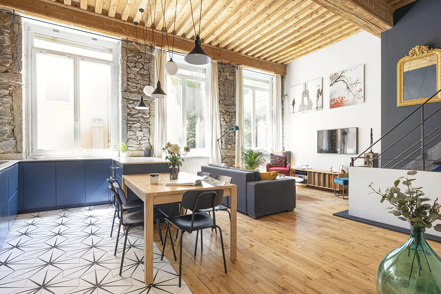 Loft canut Bon Pasteur rénové à Lyon : murs en pierre, plafond à la française et cuisine bleu nuit sur mesure